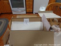 Box opened showing dolls and packing material inside packaging boxes