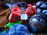 Photo showing red oriental style costume, green suspenders, and blue striped fabric piece.