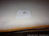 Top view showing the surface of a single foam cushion with a label '97' placed on it.