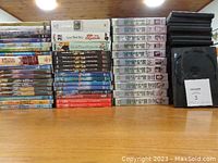 Stack of DVDs including TV show M.A.S.H. seasons and empty DVD cases.