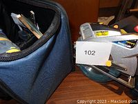 Mastercraft cordless circular saw with a visible blade guard and safety yellow lock on top, partially inside a blue carrying bag.