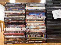 Stacks of DVD cases showing many movie titles and black empty DVD cases stacked separately