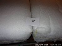 Two thick, white, high density foam cushions side by side with a label '85' on top