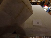 Two thick rectangular high density foam cushions with white fabric covering, shown on a table with a label '86'. Visible seams on cushions.