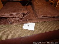 Close-up photo showing the textured fabric cover of the large cushion with a woven pattern and beige tones.