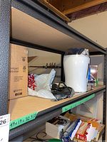 Pulmo-Aide Compact Compressor Nebulizer box with nebulizer equipment on shelf alongside a white Sunbeam humidifier and other medical items