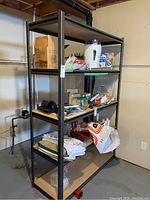 Full view of shelving unit in basement with various household items on the shelves.