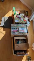 Four boxes filled with vintage sewing patterns, fabric scraps, threads, and sewing notions