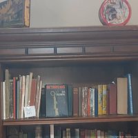 Shelf of books with titles including 'Octopussy' by Ian Fleming, various hardcover editions, and other assorted titles in fair condition.