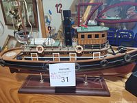 Side view of the model Nova Scotia Troller boat on wooden display stand with identification note.