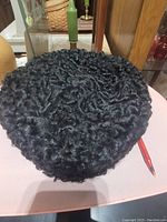 Top view of vintage black sheep wool hat showing curly textured wool surface