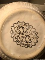 Close-up of TG Green marking on bowl base showing floral logo and number '210'