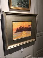 Frontal view of framed oil painting hung on wall