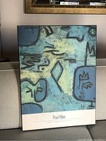 Full view of the Paul Klee art print mounted on board, resting against a beige couch.