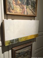 Frontal view of the Ben Stansfield contemporary oil painting hung on the wall among other framed paintings. Shows the rectangular horizontal shape with mainly white upper area and yellow-green detailed band near the bottom.