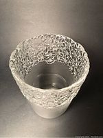Top and inside view of the vase showing the clear glass base and detailed daisy floral motif pattern embossed around the upper rim.
