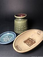 Three items shown together: forest green textured West German vase, blue Bingham signed small dish, beige oval signed dish with decorative panels
