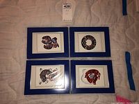 Overview of the four framed Indigenous style art prints arranged on a surface, showcasing the blue frames and individual designs.