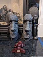 Frontal view showing the two Moai head bookends, two standing figurines behind, and the carved face bust in front.