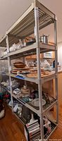 Two beige resin utility shelves filled with various kitchen and household items for staging. Shelves are empty per seller description.