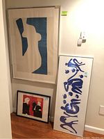 Group of three framed art prints leaning against wall