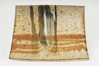 Full view of rectangular pottery wall art piece with textured glaze in earthy and dark tones.