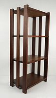Angled side view of the oak bookshelf showing three shelves and vertical slats on sides.