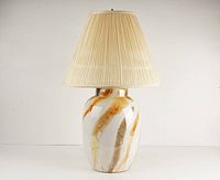 Front view of entire table lamp showing ceramic base with marbled swirl pattern and pleated cream lampshade