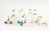 Wide view of the full lot showing all vintage glass decorative items including figurines, glass flowers, vases, and bowls arranged in a row.