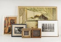 Seven framed pieces arranged on a white surface including prints, photos, and art. Large window scene, black and white forest photo, child near bookshelves, and two small spider web artworks visible.