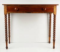 Front view showing single drawer and turned legs