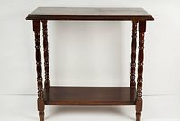Front view of the small vintage wooden side table showing the rectangular top and turned spindle legs.