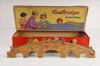 Colorful cardboard bridge piece designed as a stone bridge with illustrations of children characters, part of the Cuebridge game.