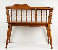 Front view of wooden hall telephone bench showing spindled backrest and four legs