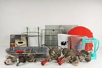 Overview photo showing all vintage kitchen items laid out including hand mixers, blue enamel pan, milk bottles, wire racks, plastic dough blender, and hot pad