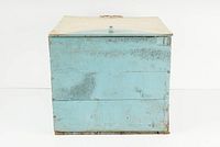 Front view of vintage wooden kitchen box painted light blue with hinged off-white lid.