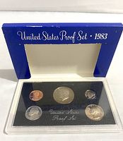 Front view of the 1983-S US Proof Coin Set showing the coins in a clear plastic holder with the original blue cardboard display frame.