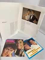 Open Wham! concert program pages showing colored photographs of band members, and two 45 records placed beneath the program.