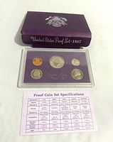 Purple cardboard envelope with silver embossed emblem and text