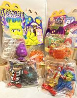 Vintage 1995 McDonald's Halloween character toys sealed in original bags with two themed cardboard boxes in background.