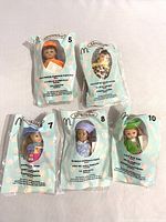 Five Madame Alexander dolls in original sealed plastic bags: Ladybug Girl, two Halloween costume dolls (pumpkin and leopard), Hannah Pepper, and Hannah Pepper's Friend