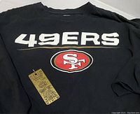 Close-up of black 49ers T-shirt front with logo and tag