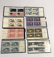 Front view showing nine blocks of uncancelled US stamps in protective sleeves, various designs and denominations.