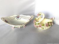 Photo of the two fine china decorative pieces, the swan figurine and floral bowl side by side showing their size and details.