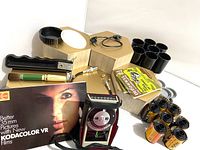 Overview of the vintage camera accessories including the Vivitar No. 30 light meter, Kodak film rolls, cleaning cloths, film booklet, and other small parts.