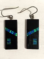 Front view of rectangular onyx earrings with created opal insets, silver hooks visible.