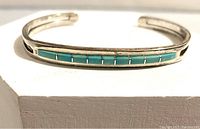 Front view of the sterling silver turquoise bracelet showing the inlaid rectangular turquoise stones in a row.