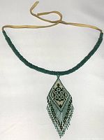 Full view of turtle bead necklace showing beaded section and leather cord