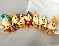 Seven plush dolls of the Disney Seven Dwarfs lined up