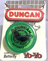 Front image of a green translucent plastic Duncan Butterfly yo-yo sealed on original 1994 Duncan branded cardboard backing with butterfly logo and text.